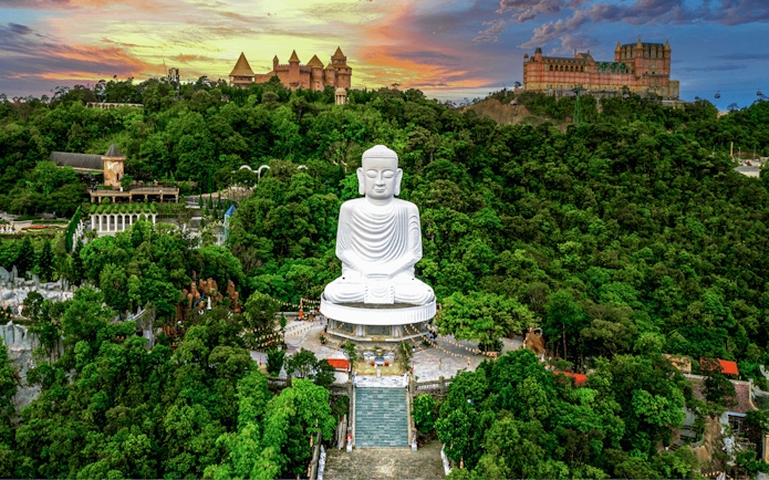 Aerial view of Buddha statue surrounded by lush greenery at Bana Hills, Da Nang, Vietnam.