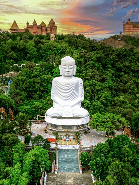 Aerial view of Buddha statue surrounded by lush greenery at Bana Hills, Da Nang, Vietnam.