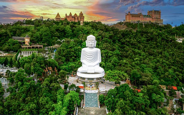 Aerial view of Buddha statue surrounded by lush greenery at Bana Hills, Da Nang, Vietnam.