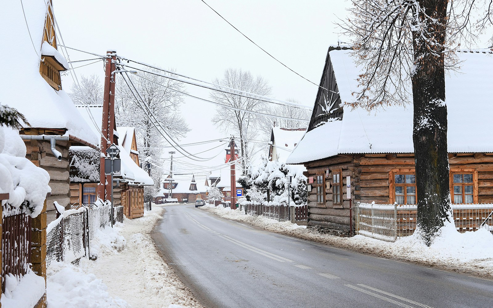 Snow-covered wooden houses in a village near Zakopane, Poland, during a winter tour from Krakow.