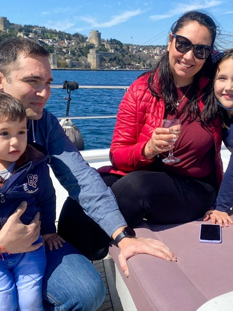 Family enjoying Istanbul Bosphorus cruise with Rumeli Fortress in the background.