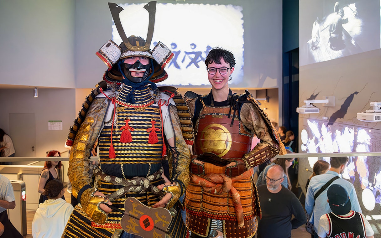 Samurai Museum visitors in traditional armor, Tokyo exhibit.