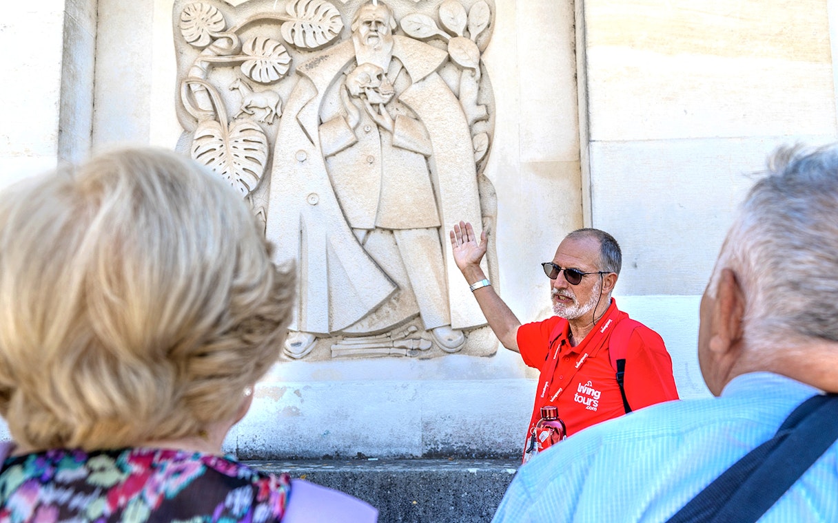 Tour guide explaining a stone relief in Coimbra during Fátima & Coimbra full-day tour from Porto.