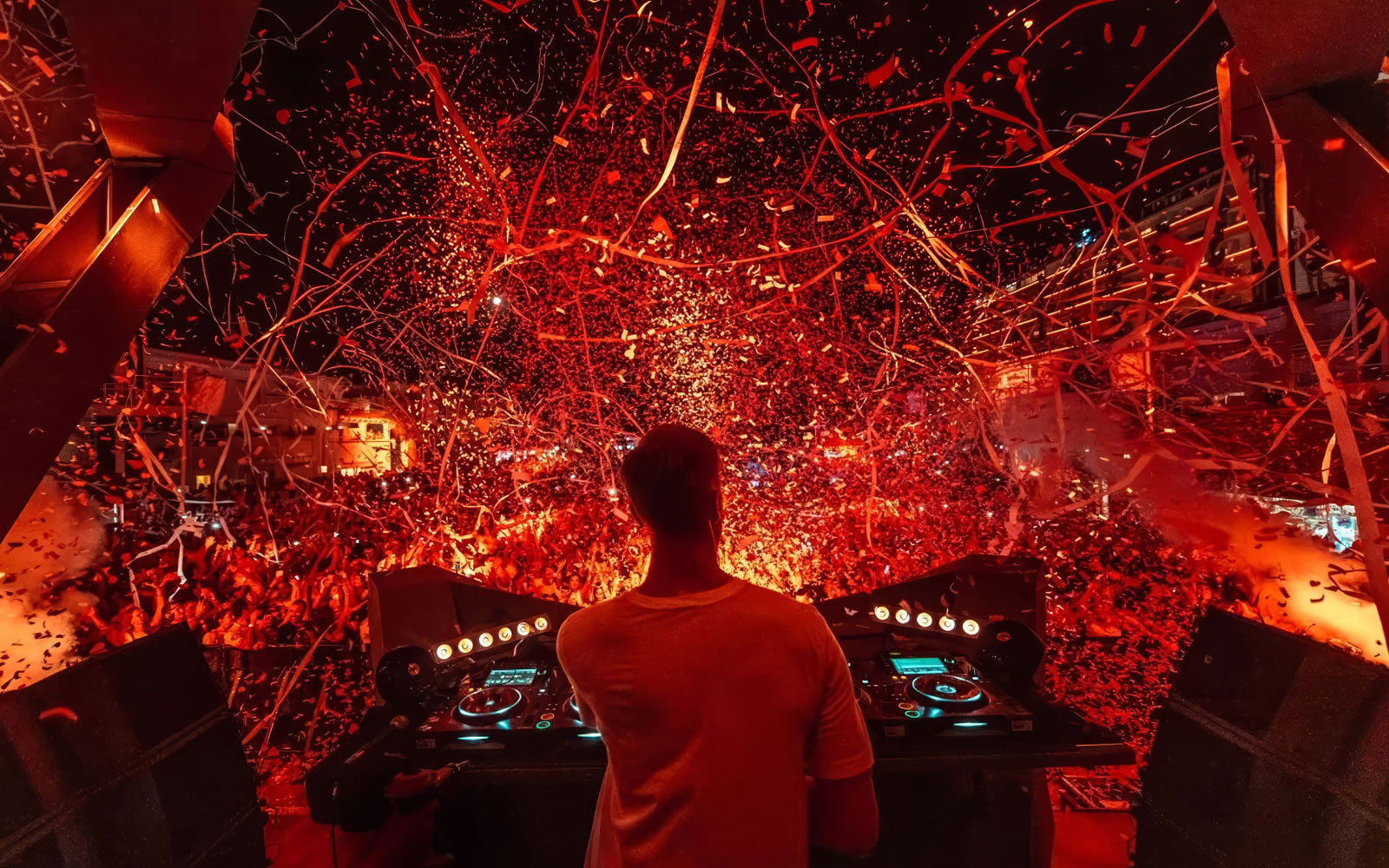 DJ performing at Ushuaïa Ibiza with vibrant confetti and crowd.