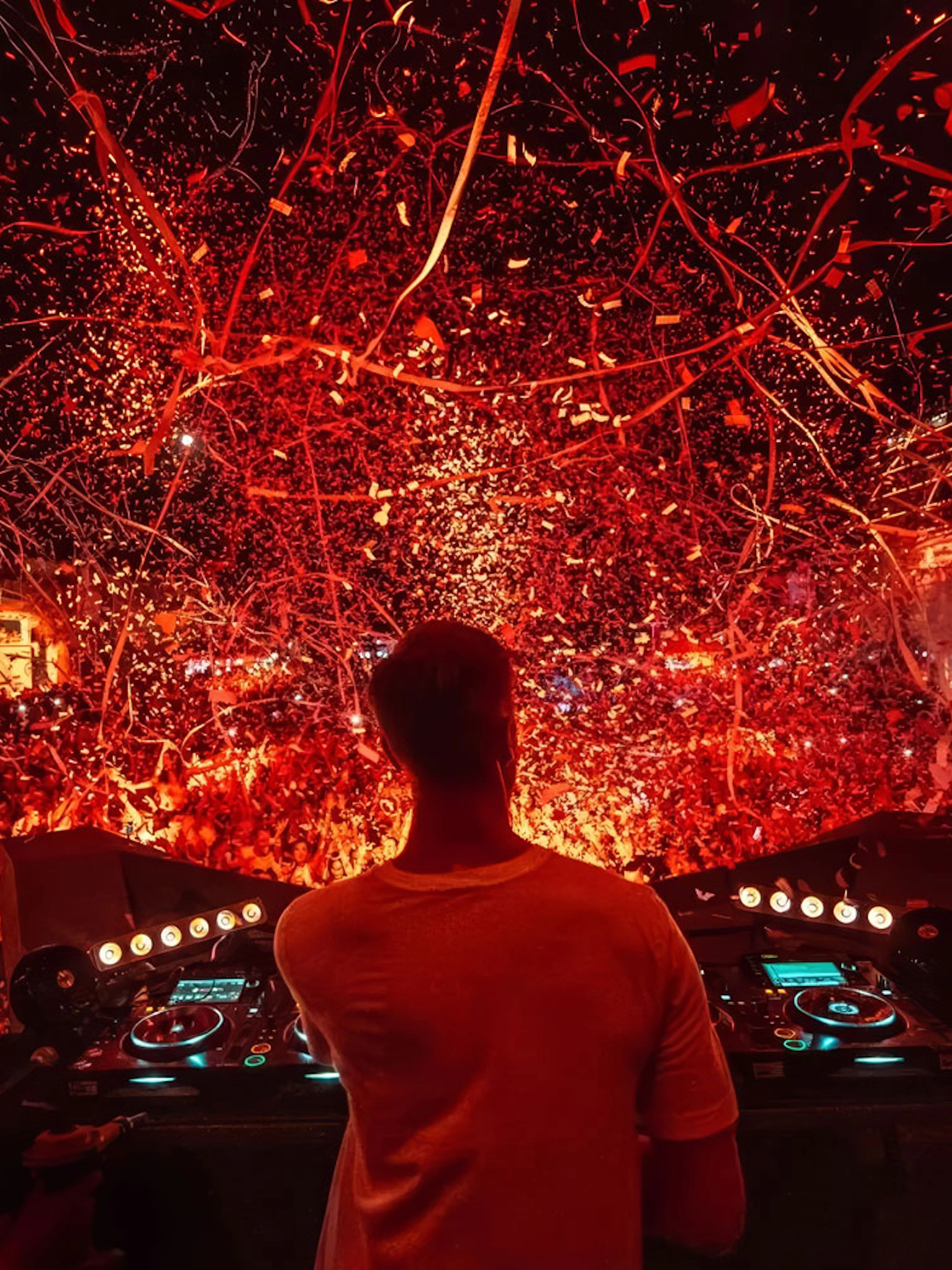 DJ performing at Ushuaïa Ibiza with vibrant confetti and crowd.