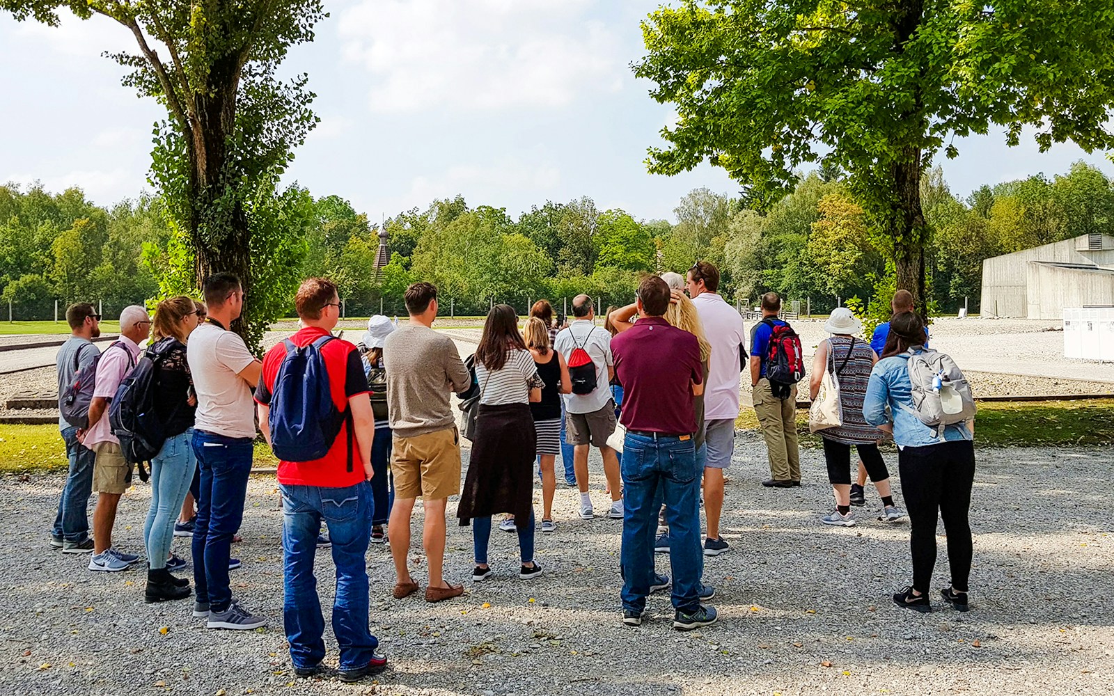 Visitors walking through Dachau Concentration Camp, Germany, observing historical exhibits.