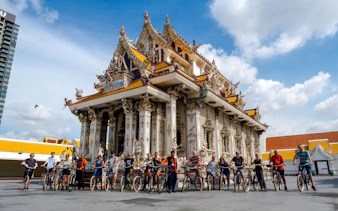Cyclists in front of ornate temple during Bangkok Beyond Bicycle Ride.