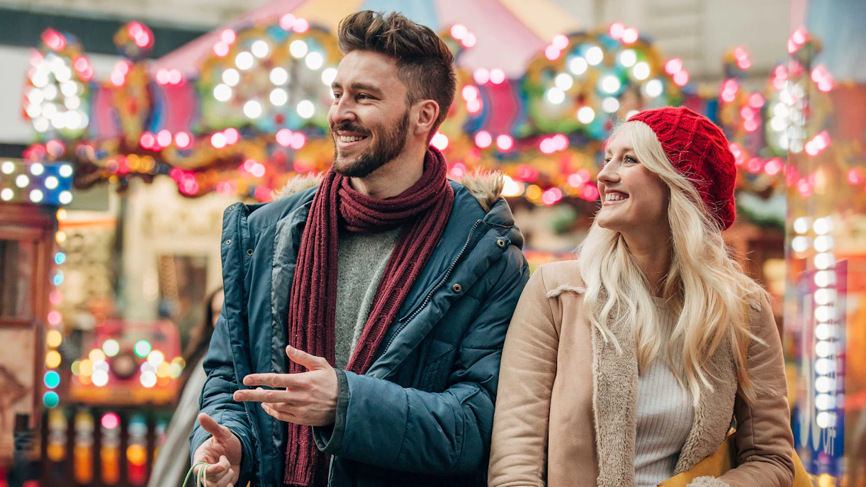 Couple shopping during holiday sales in a festive city market.