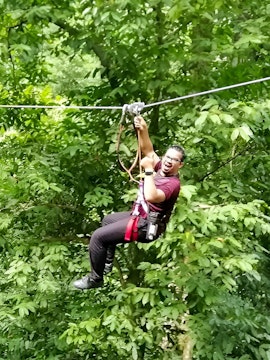 Person ziplining through lush forest at SKYTREX Adventure Langkawi.