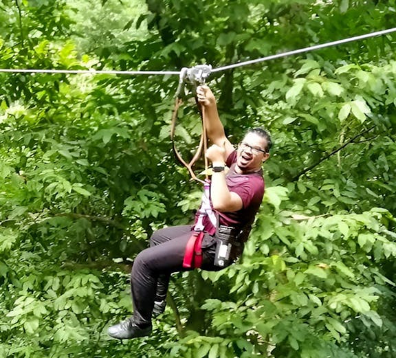 Person ziplining through lush forest at SKYTREX Adventure Langkawi.