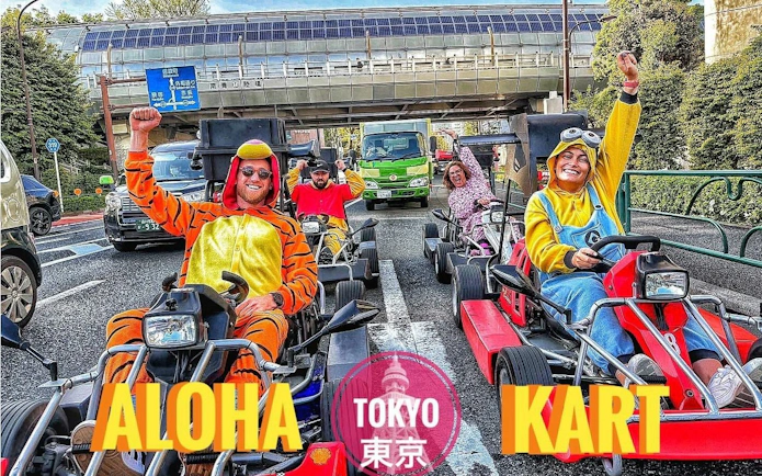 Tourists in costumes driving go-karts on a Tokyo street during a guided tour.