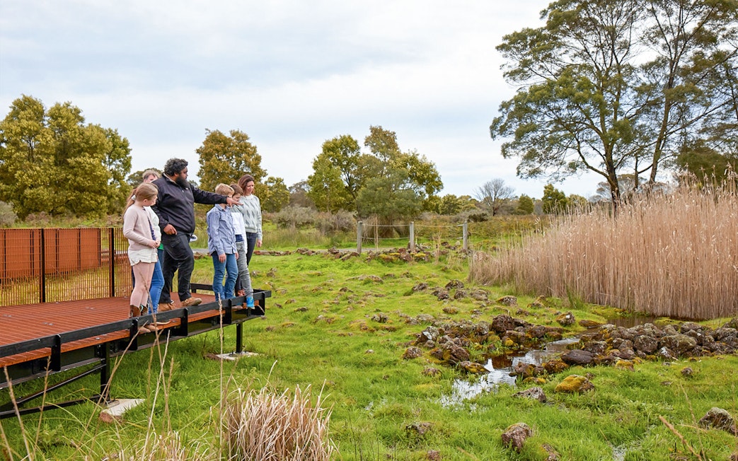 Group on boardwalk during Kooyang Yana full day tour, observing wetlands and landscape.