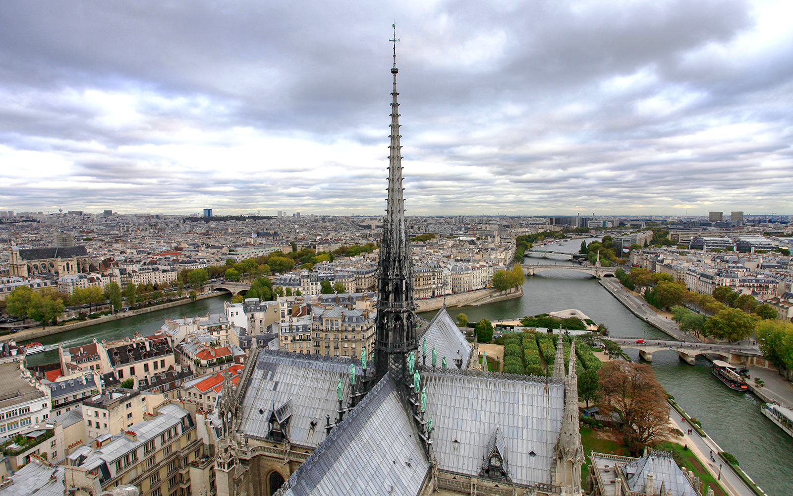 Notre Dame Cathedral spire in Paris, France, viewed from below against a clear sky.
