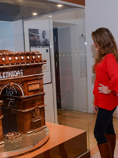 Woman observing chocolate Arc de Triomphe at Choco-Story Paris museum.