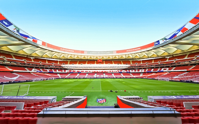 Atlético de Madrid stadium interior with empty seats and green field.