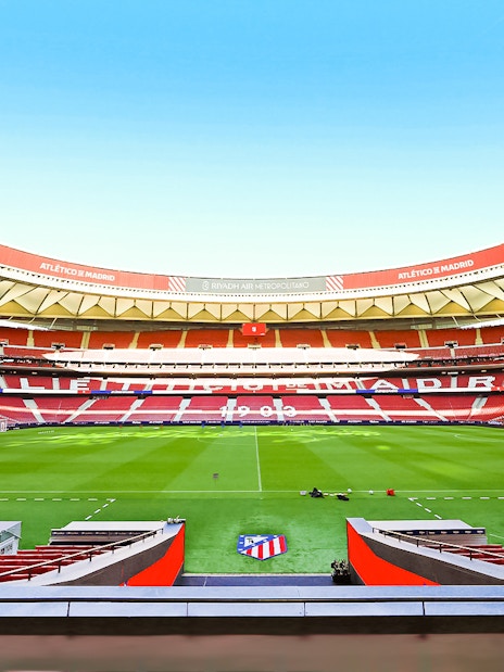Atlético de Madrid stadium interior with empty seats and green field.