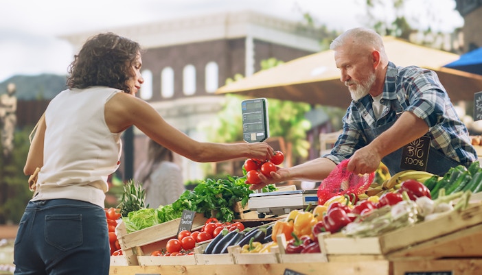 A customer buying vegetables at the Farmer's market