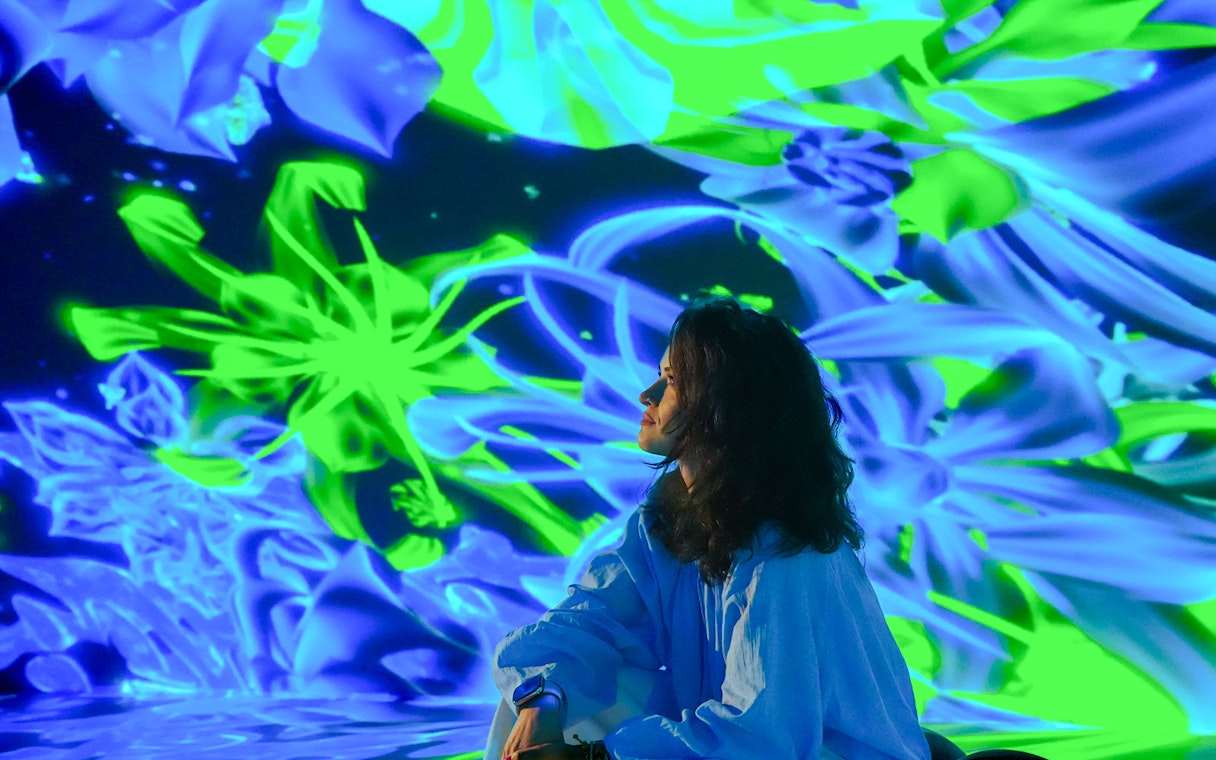 Tourist admiring digital art display at House of Hype, Dubai.