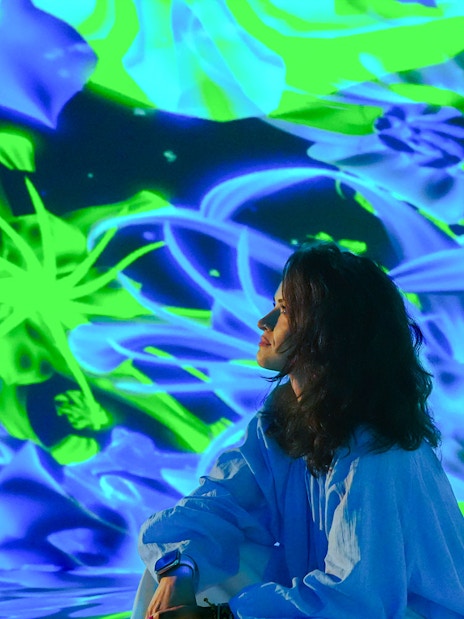 Tourist admiring digital art display at House of Hype, Dubai.