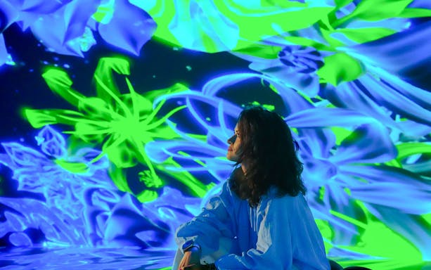 Tourist admiring digital art display at House of Hype, Dubai.