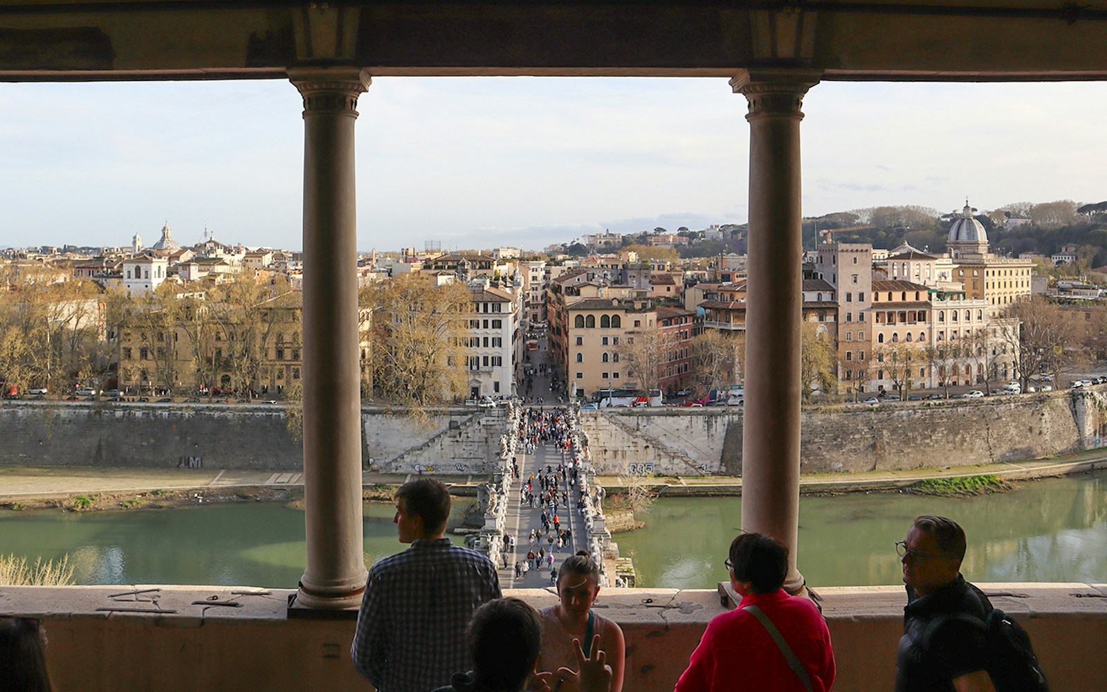 People walking on St. Angel Bridge towards Castel Sant'Angelo in Rome, Italy.