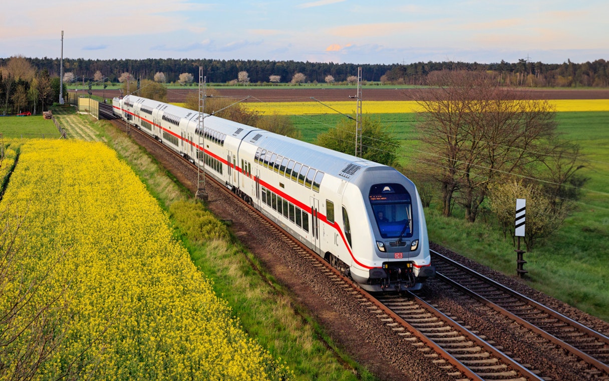 Interrail train traveling through scenic countryside in Germany.