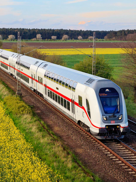 Interrail train traveling through scenic countryside in Germany.