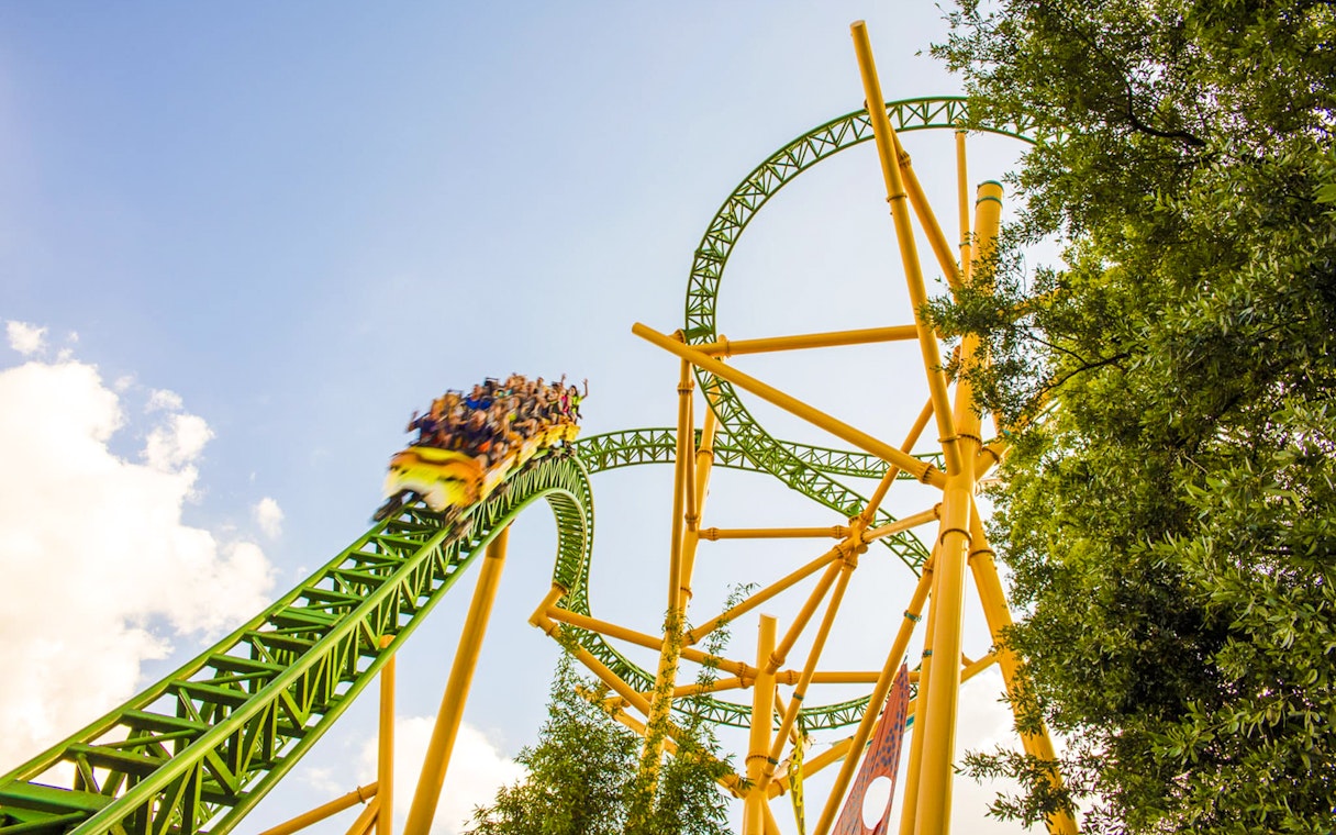 Roller coaster at Busch Gardens, Tampa Bay with riders on a green and yellow track.