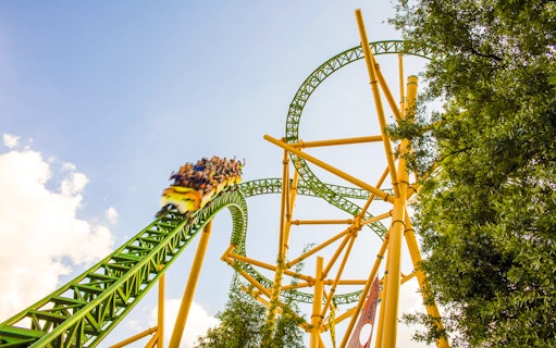 Roller coaster at Busch Gardens, Tampa Bay with riders on a green and yellow track.