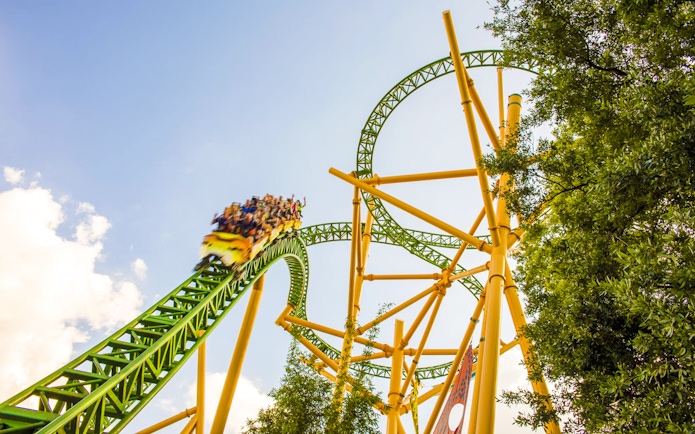 Roller coaster at Busch Gardens, Tampa Bay with riders on a green and yellow track.