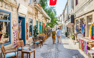 Couple walking down a cobblestone street lined with shops and cafes in Vialand Theme Park.