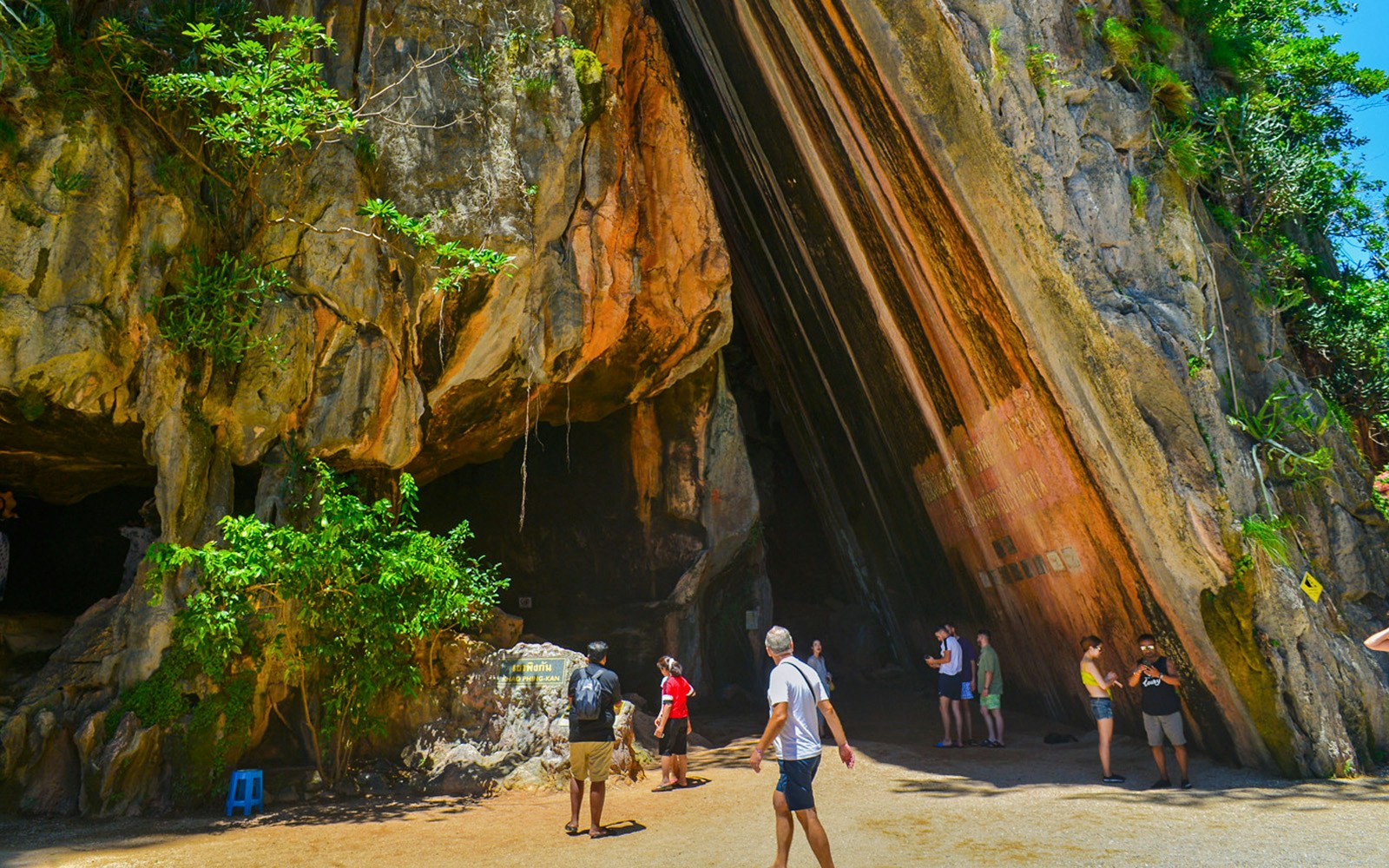 Tourists exploring cave entrance at James Bond Island, Phang Nga Bay.