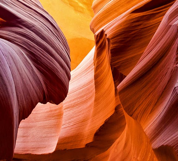 Antelope Canyon's swirling sandstone formations in vibrant orange and purple hues.