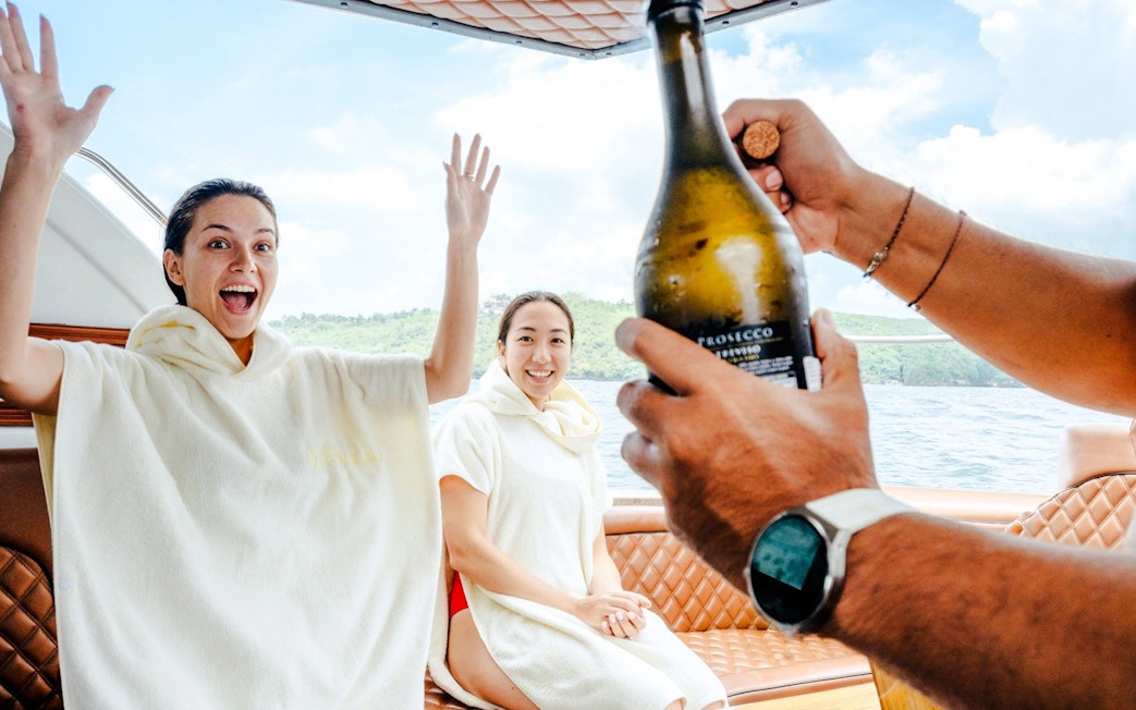 Boat tour from Bali to Nusa Penida with people celebrating and enjoying the ocean view.