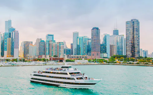 Cruise boat on Chicago River with city skyline in background.