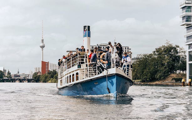 Berlin bridge cruise on the Spree River with TV Tower in the background.