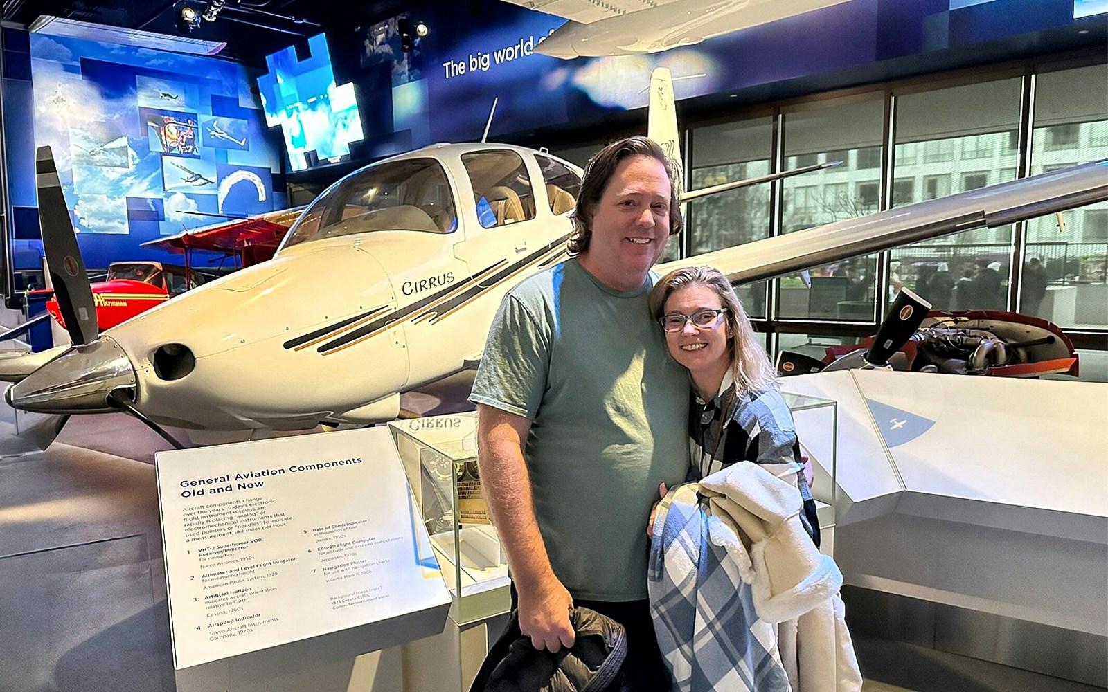 Visitors at Smithsonian's National Air and Space Museum with a Cirrus aircraft exhibit.