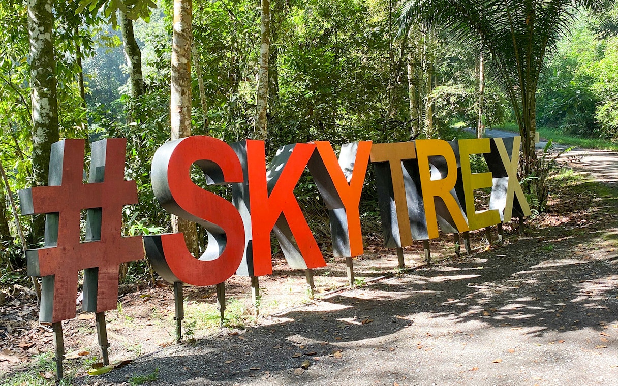 Skytrex Adventure Langkawi sign in lush forest setting.
