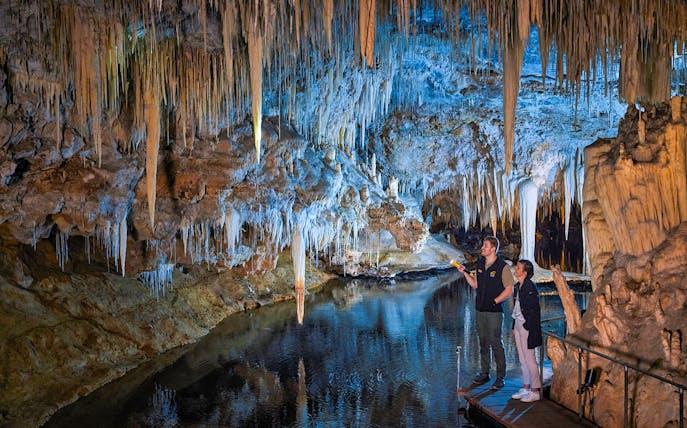 Guide points flashlight at stalactites in Lake Cave, Margaret River.