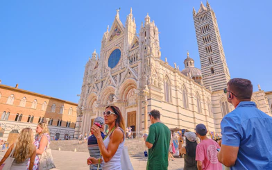 Siena Cathedral facade with tourists during the day in Siena, Italy.