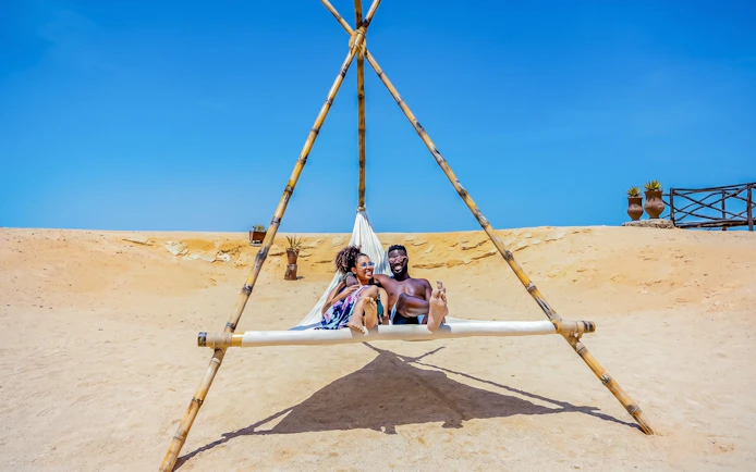 Couple relaxing on a hammock at Orange Bay, Giftun Island, Hurghada.