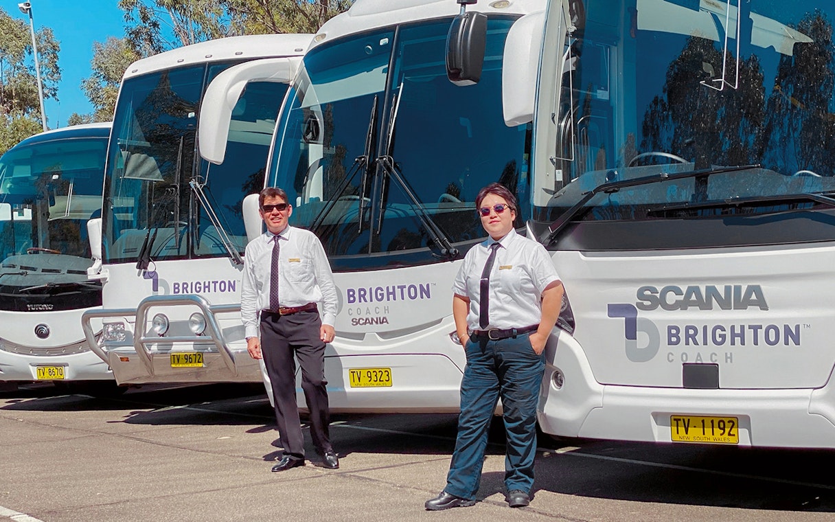 Tour guides standing in front of Brighton Coach buses for Sydney Night Tour.