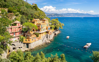 Bay of Portofino view with colorful villas and boats on a day trip from Genoa.