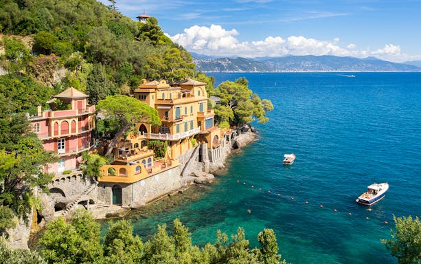 Bay of Portofino view with colorful villas and boats on a day trip from Genoa.