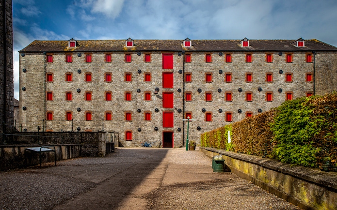 Stone building with red windows at Midleton Distillery, Ireland, for the Behind the Scenes Tour & Tasting.