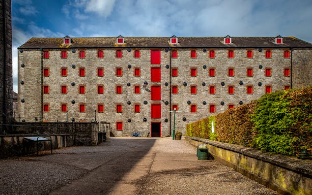 Stone building with red windows at Midleton Distillery, Ireland, for the Behind the Scenes Tour & Tasting.