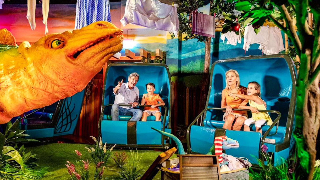 Family enjoying a dinosaur-themed ride at France attraction in Europa Park.