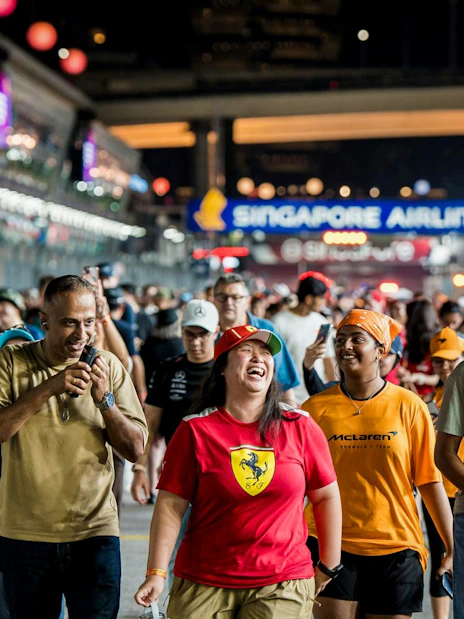 Crowd walking the track at night during Formula 1 Singapore Grand Prix.