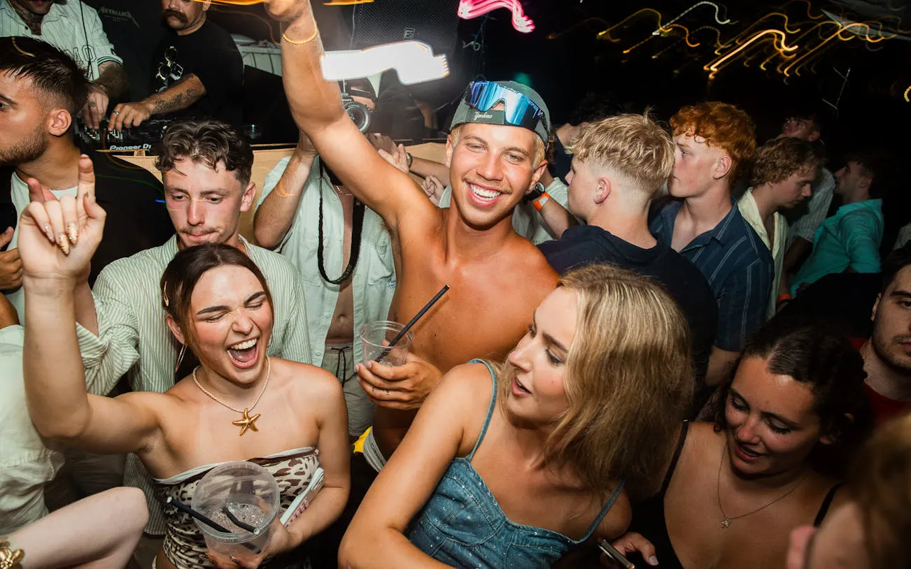 Partygoers enjoying a night boat party in Split with a live DJ and free shots.