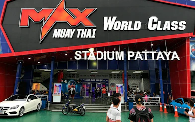 Exterior entrance of MAX Muay Thai Stadium Pattaya with visitors outside.